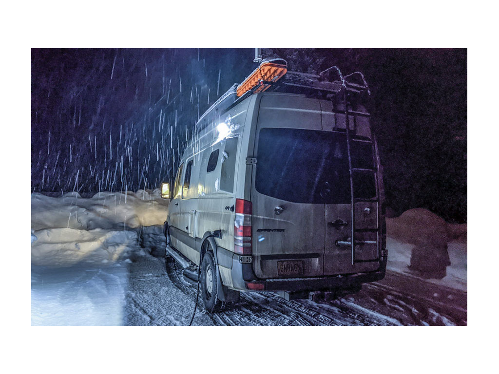 Gnar Wagon parked with snow falling around it while hooked up to electricity